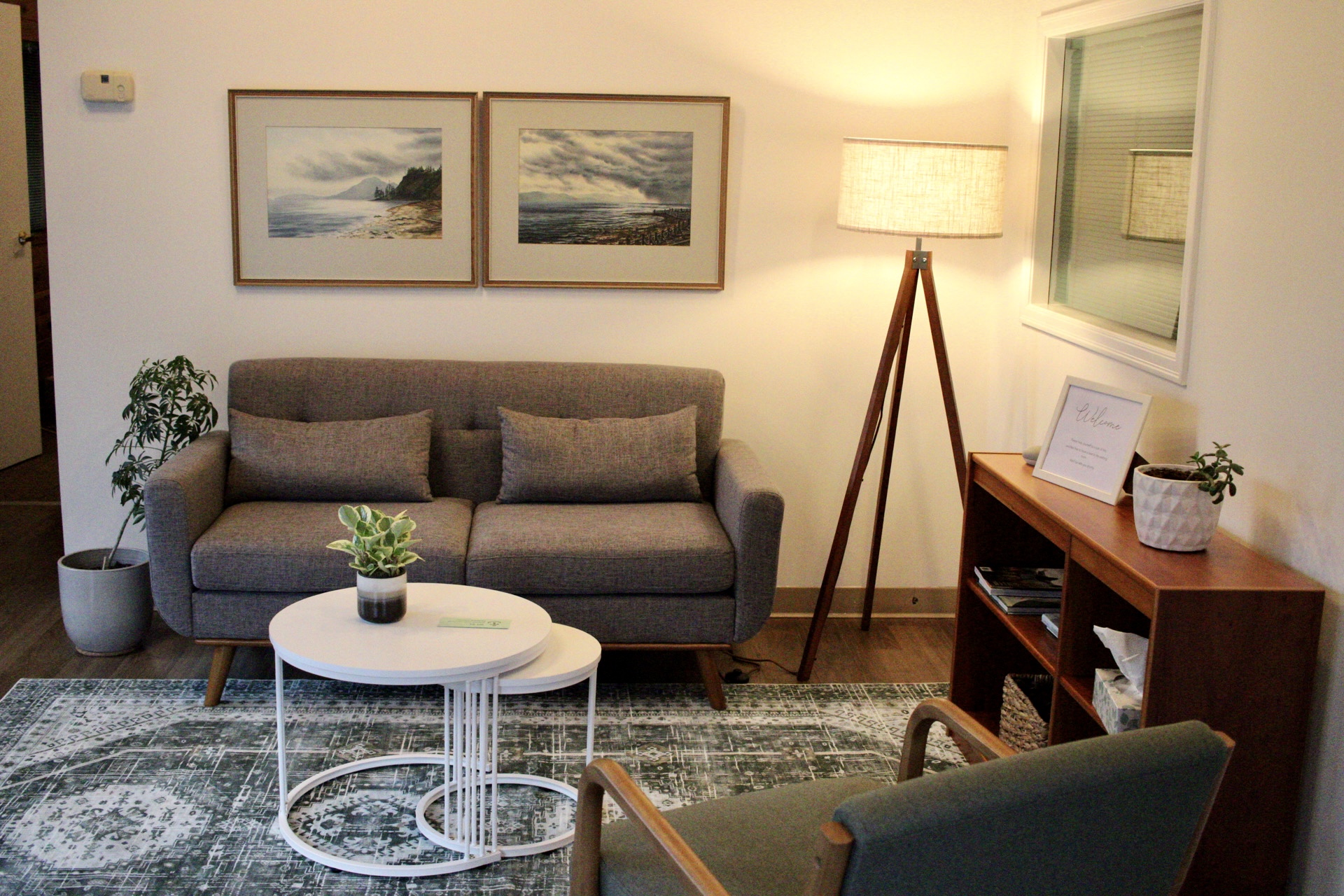 Our counselling office with a comfortable sofa, plants, and warm lighting